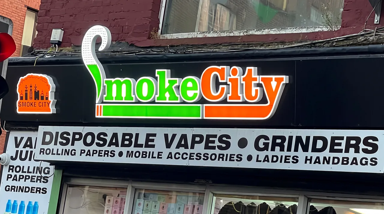 Smoke City on South Main Street, Cork: green and orange illuminated letters with a lit logo box above a printed fascia.